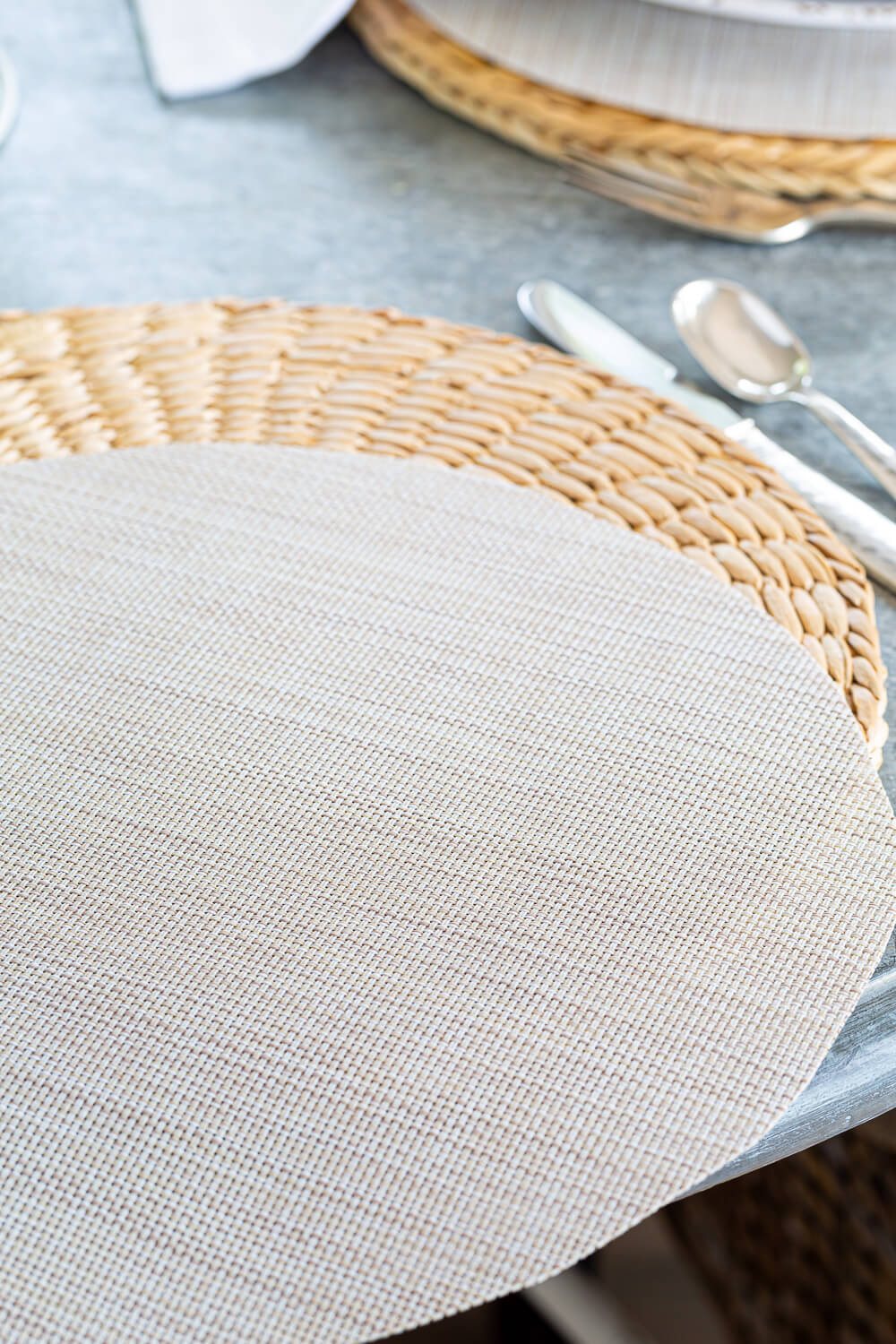 Two woven round placemats layered.