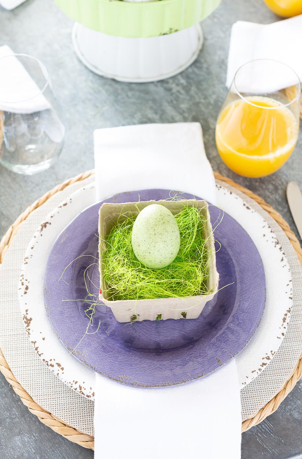 Easter brunch table setting using white and purple dinner plates.