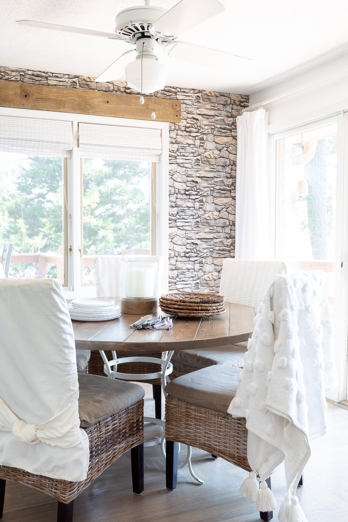 Neutrally decorated kitchen dining area with faux stone wallpaper on the walls.