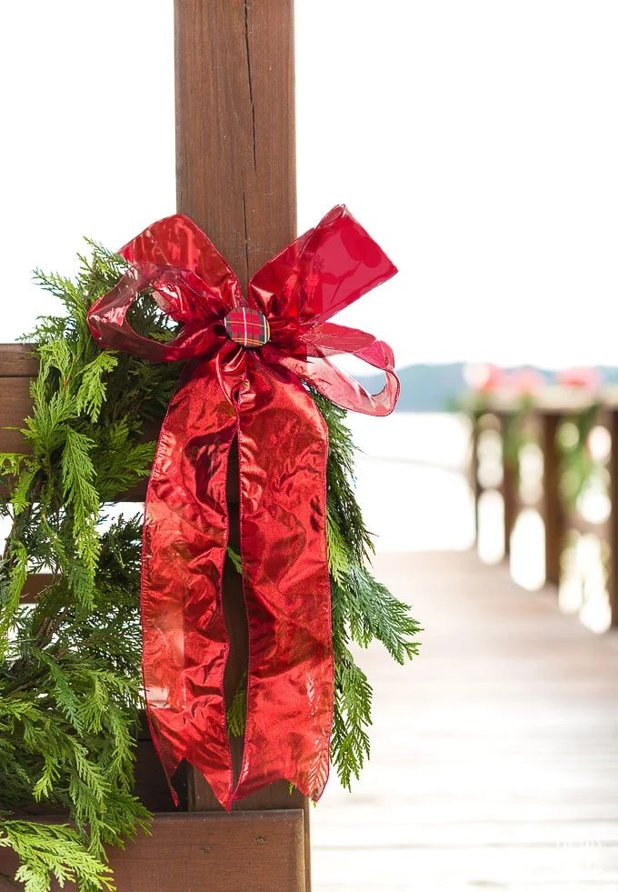 Outdoor Christmas decorating idea using cedar roping and red ribbon on a gazebo.
