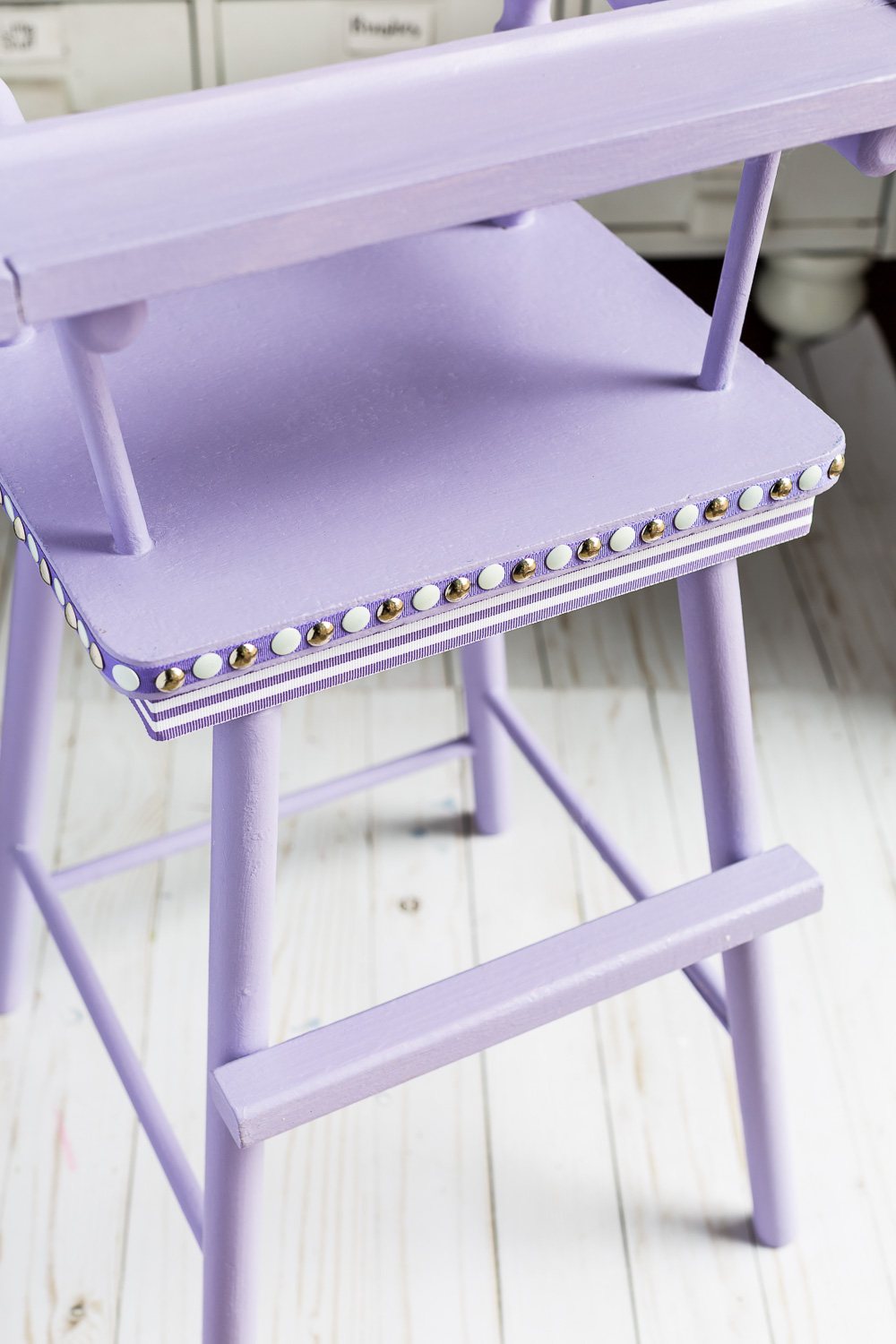 Close up shot of Lavender painted high chair using Country Chic paint with nail head trim in silver and white.