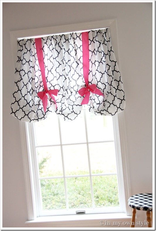 Balloon style window treatment on window using a fitted sheet and ribbon.
