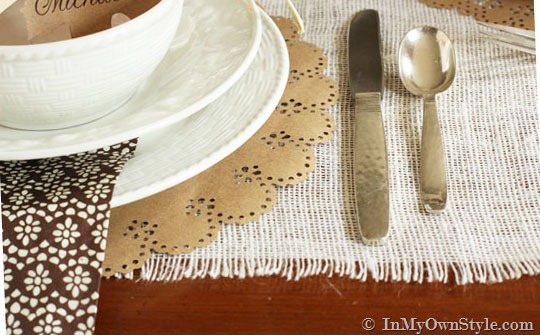 close up of white plates on a Thanksgiving table setting.