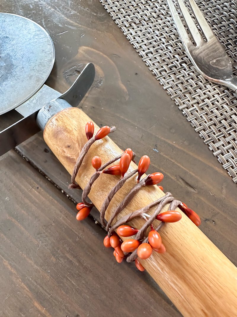 fall berries on wire wrapped around a wood handle to make a fall dinner napkin ring.