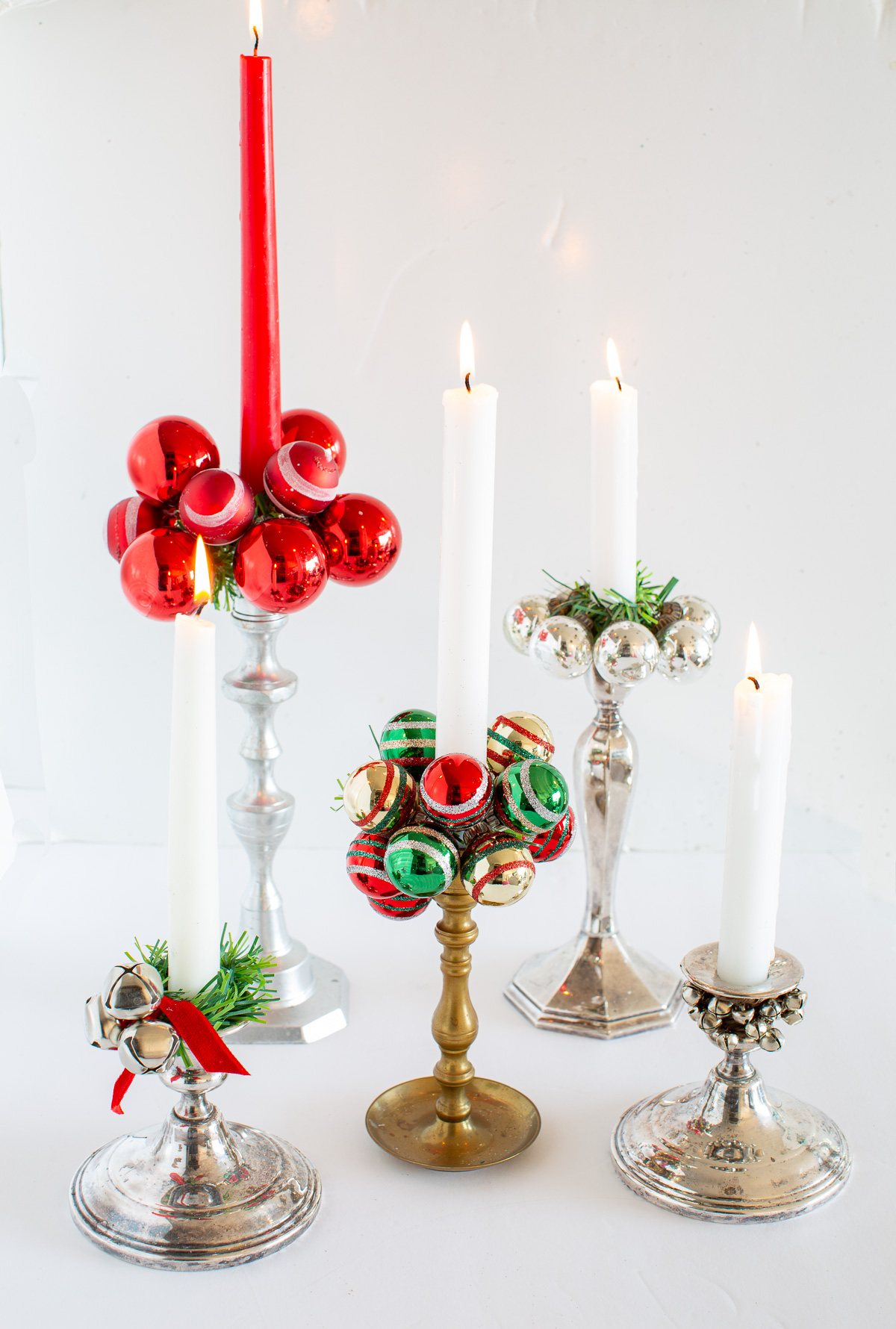 5 Creative Candle Rings DIY for Christmas made using Shiny Brite Christmas ornaments, jingle bells and faux greenery garland ties.