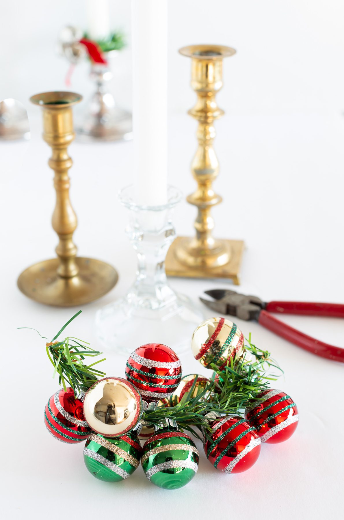 How to make a holiday taper candle ring using miniature Christmas ornaments.