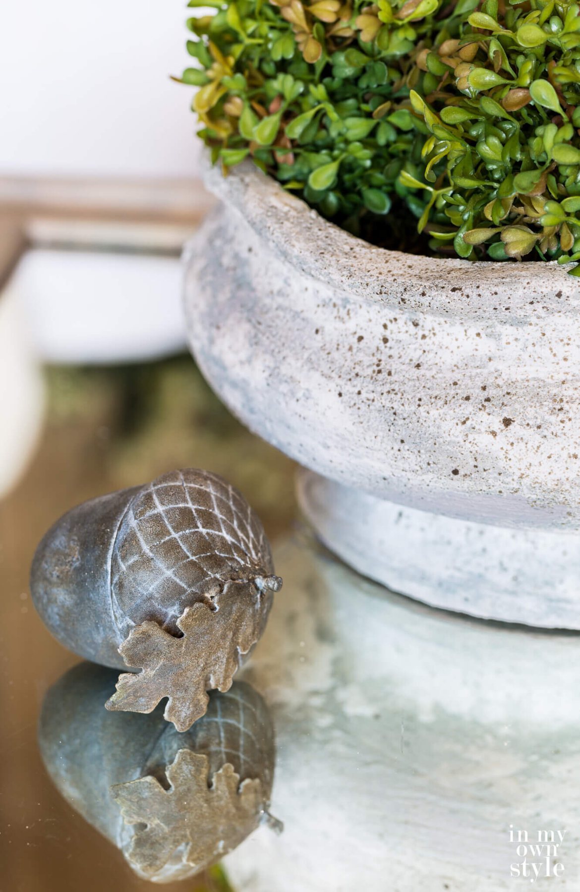 DIY concrete look finish on planter and rustic aged decorative acorn.