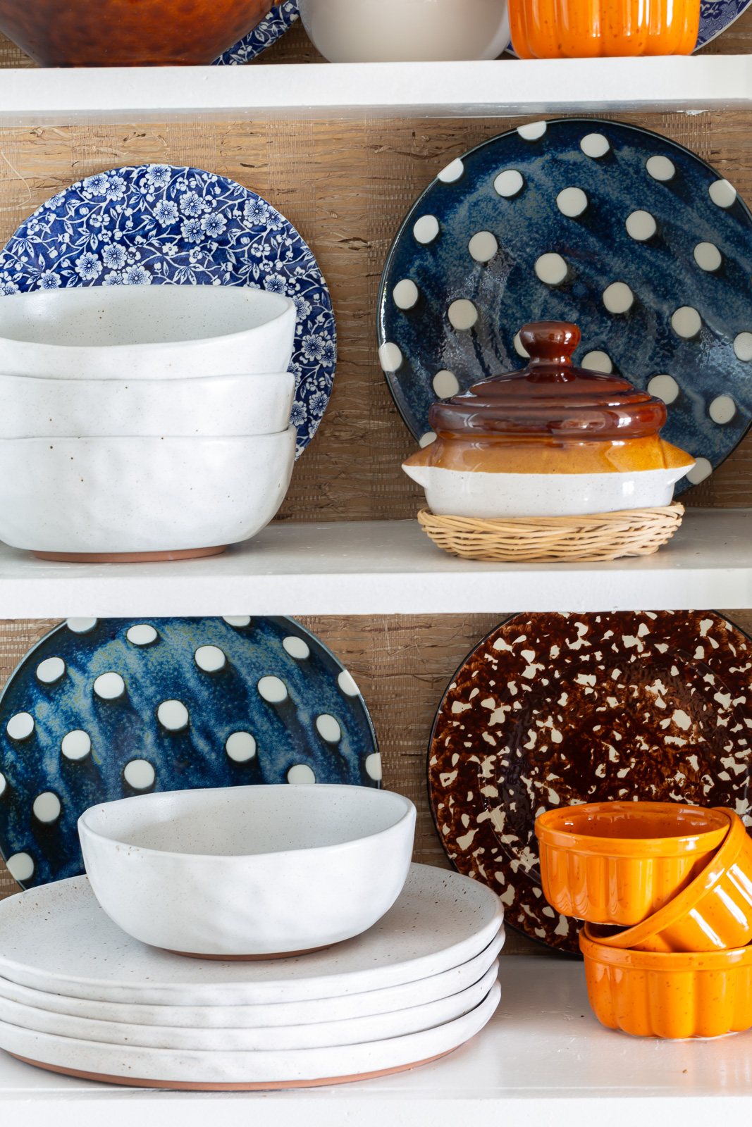 Fall colored kitchen items displayed on open shelves in a small kitchen decorated for fall.