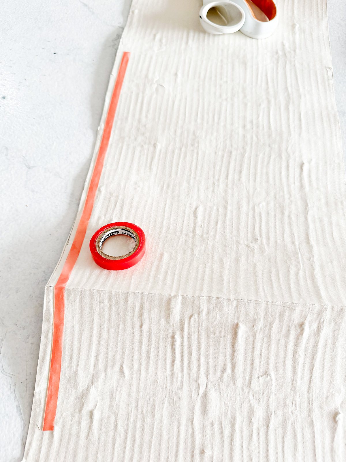 how to add red sticky tape to the back of wallpaper to hang in the back of open kitchen shelves.
