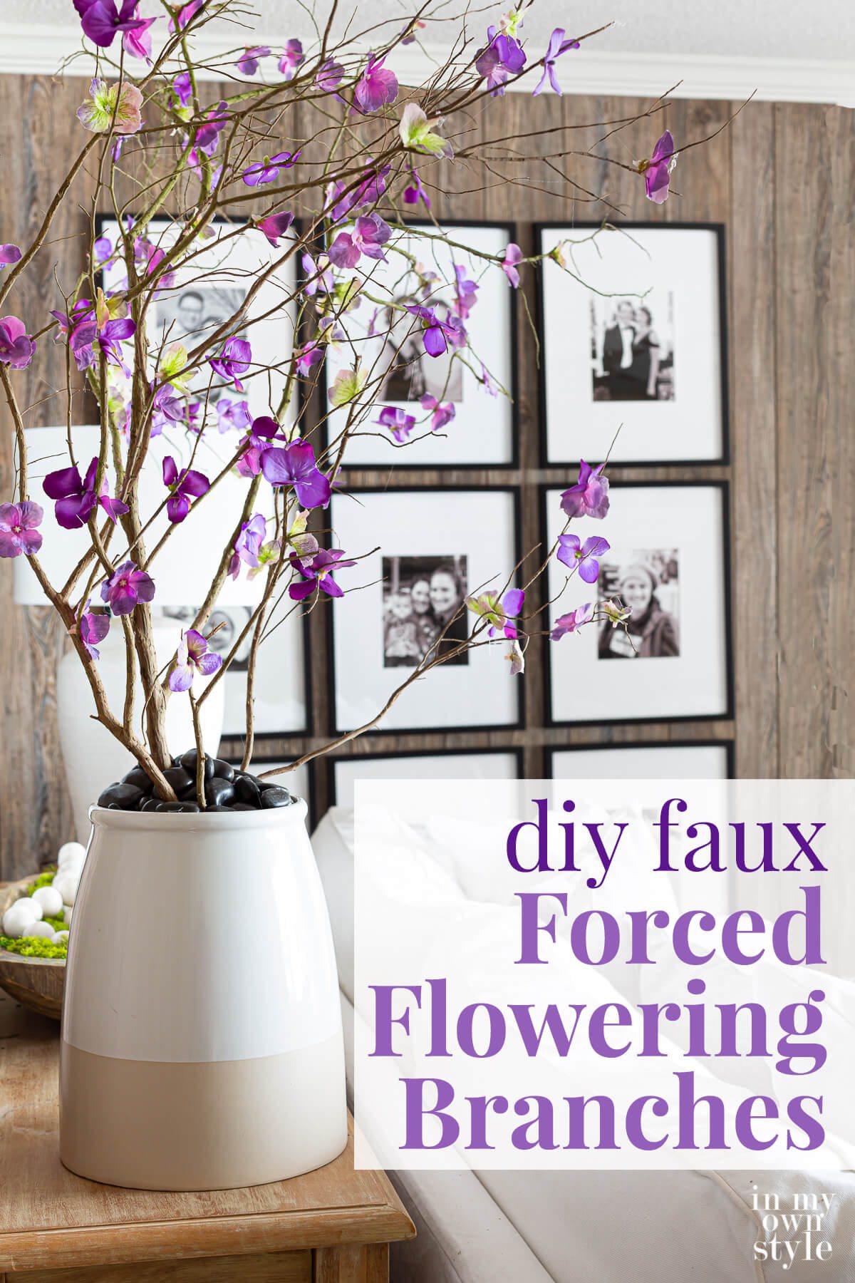 Faux blooming branches in large planter behind a sofa