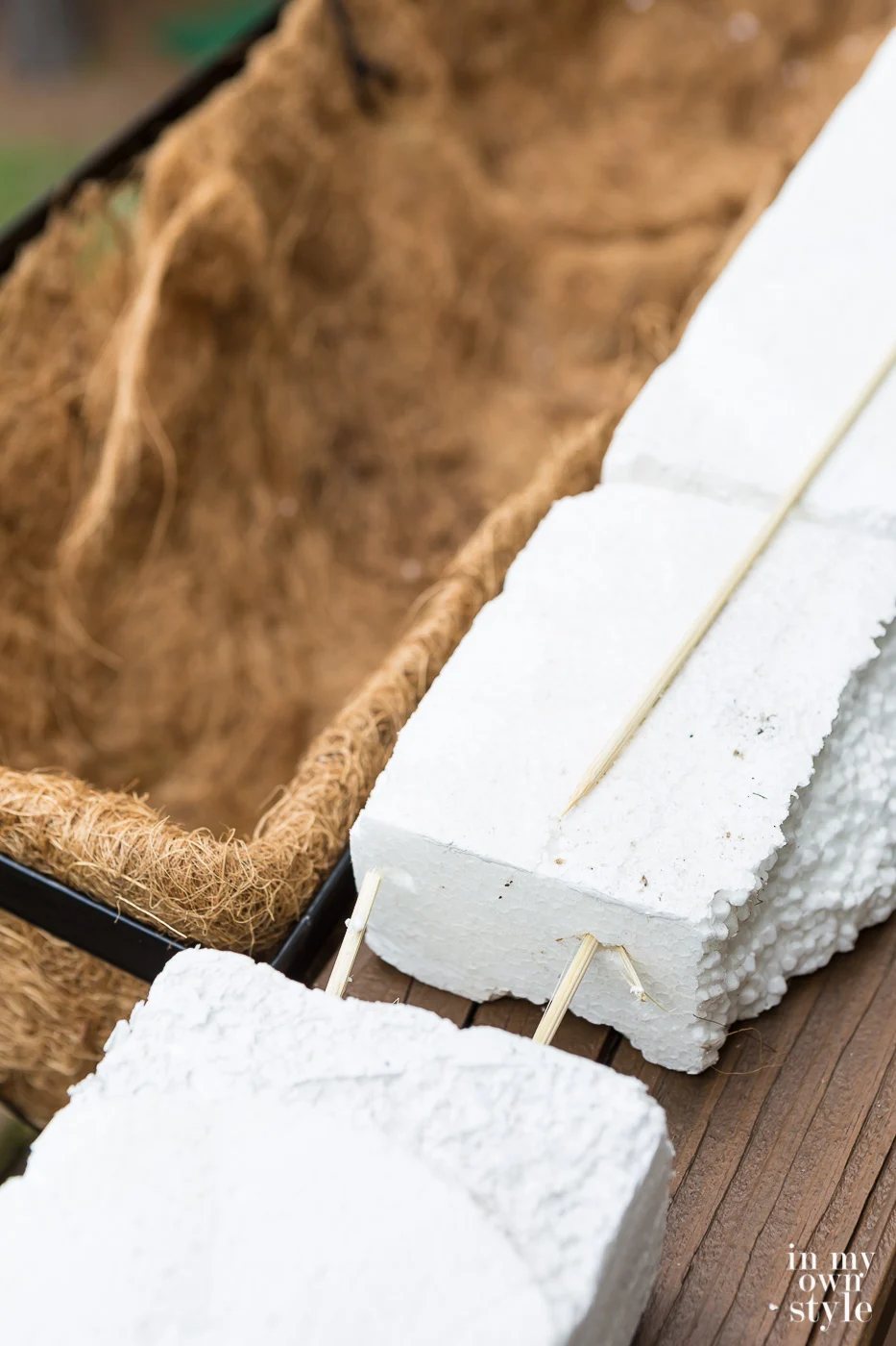 How to secure fake flowers in a window box. Styrofoam attached together with skewers to make one long piece.