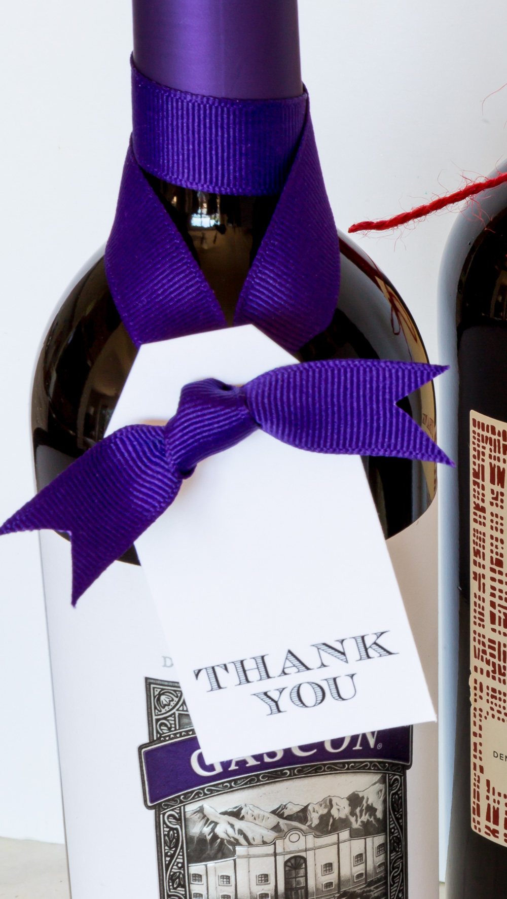 a bottle of wine with a free printable thank you gift tag tied on.