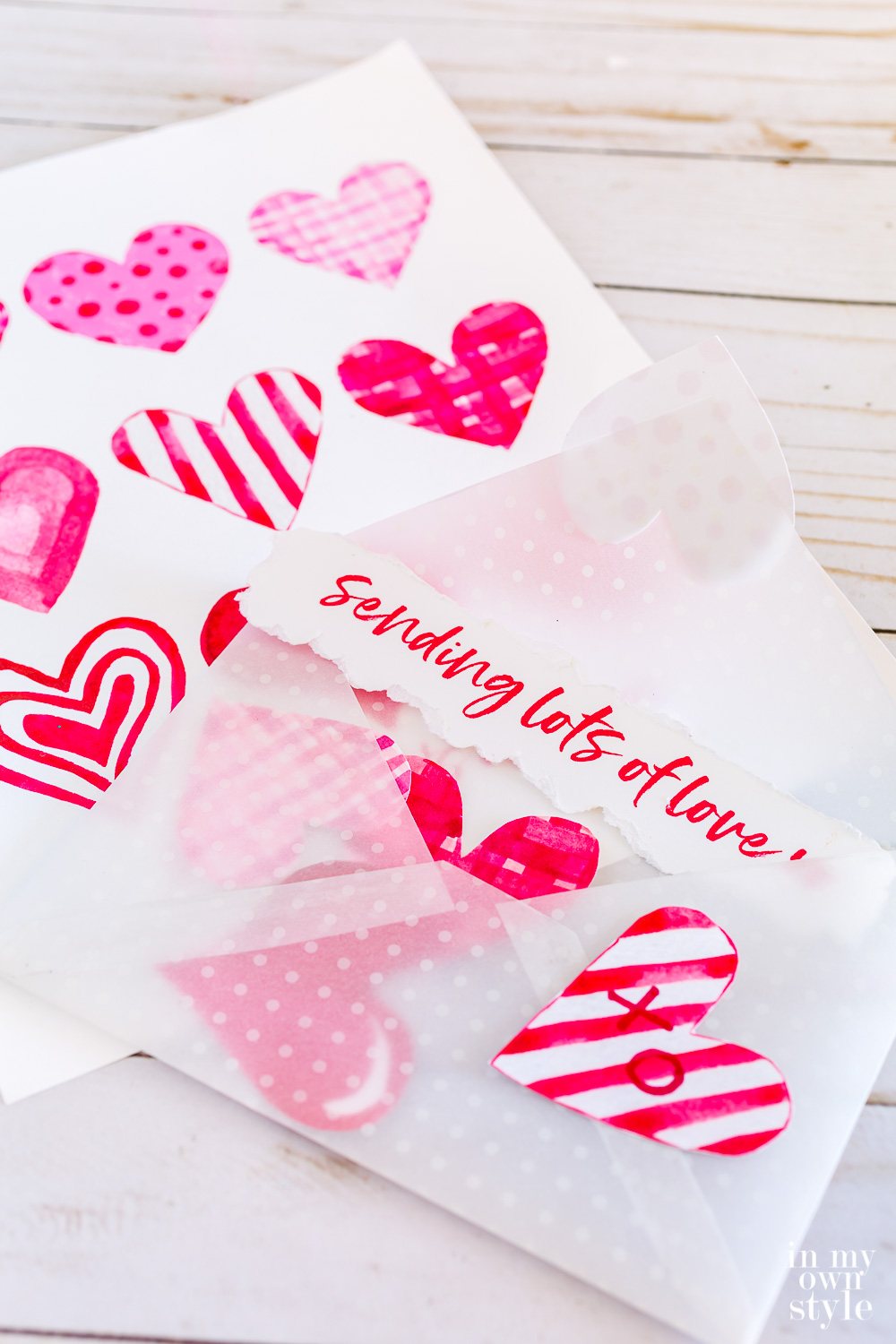 Free printable Valentine envelope filled with pink and red watercolor hearts.