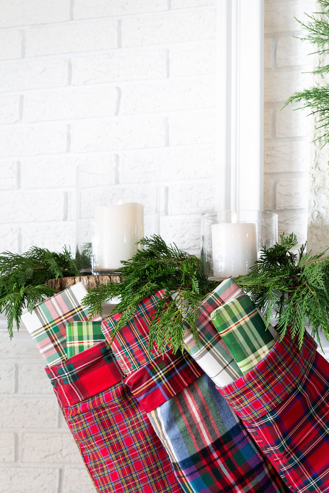 plaid Christmas stockings hanging from a mantel.