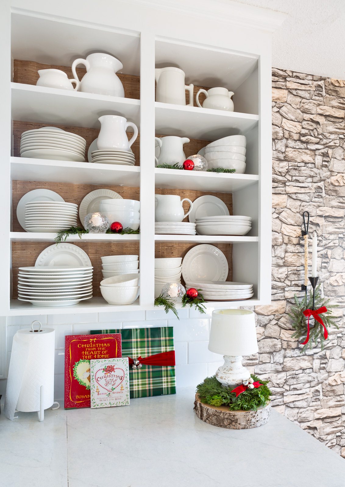 Kitchen counter and open shelves decorated for Christmas.