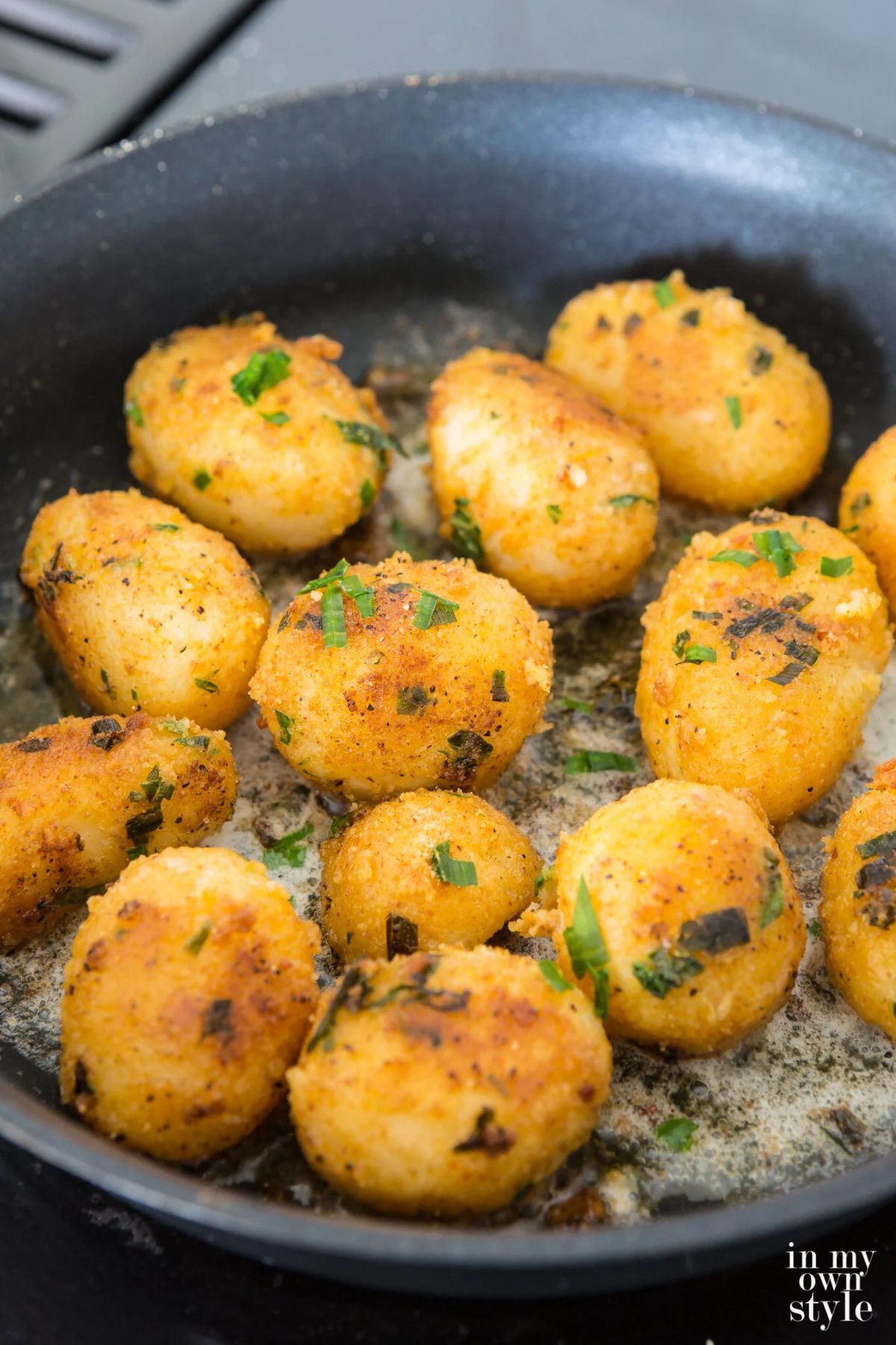 Herbed Canned potatoes being fried in butter in a frying pan.