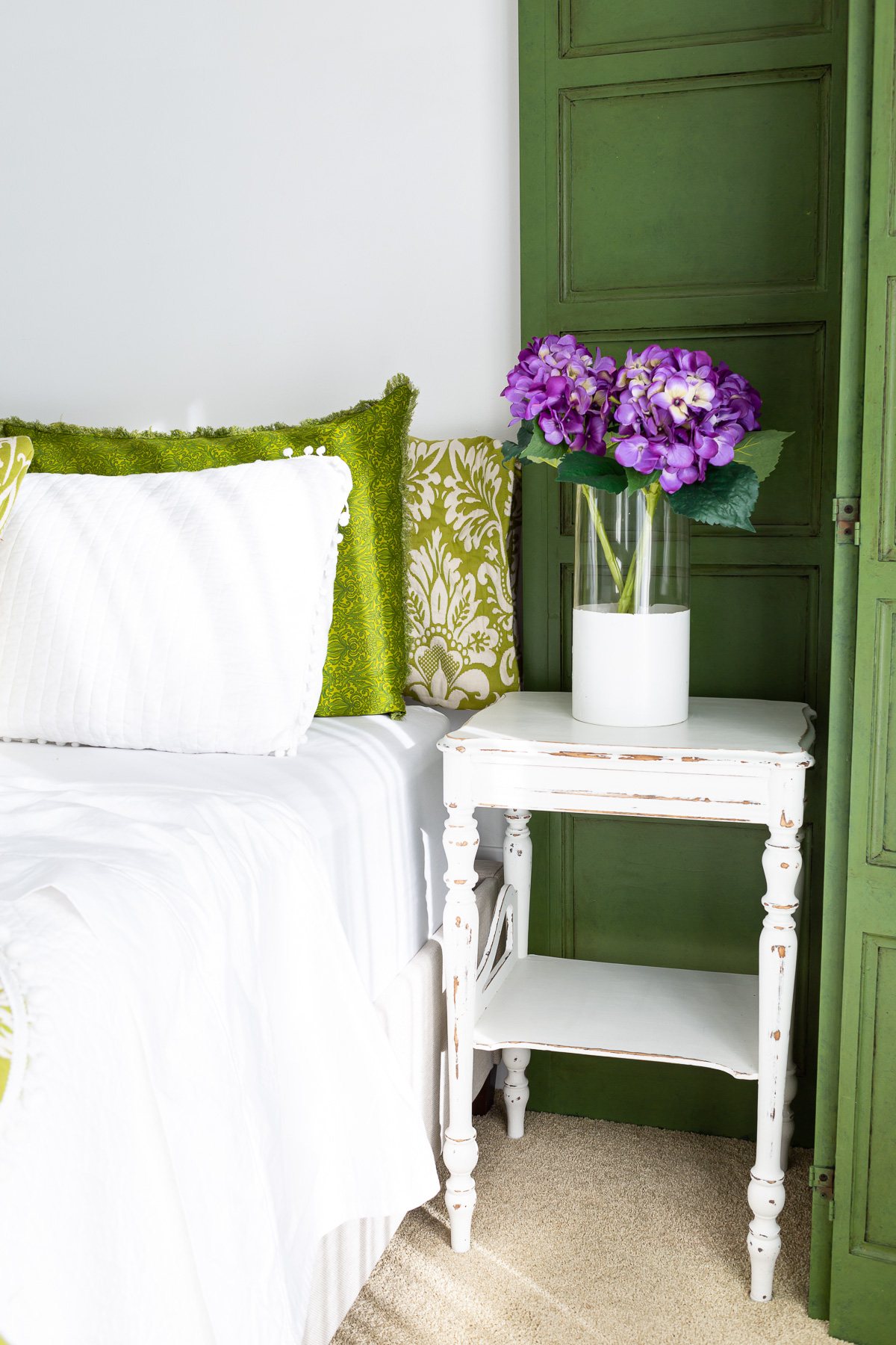 green and white guest room with purple accents