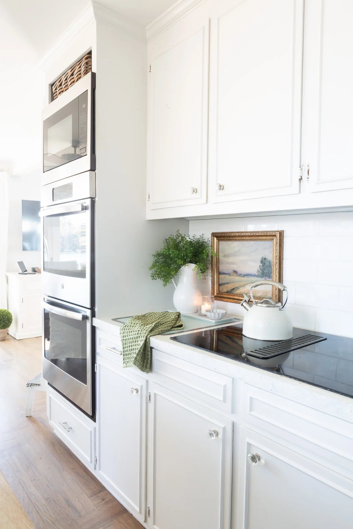 a view of a long wall in a kitchen where framed art is hung on the tile backsplash.