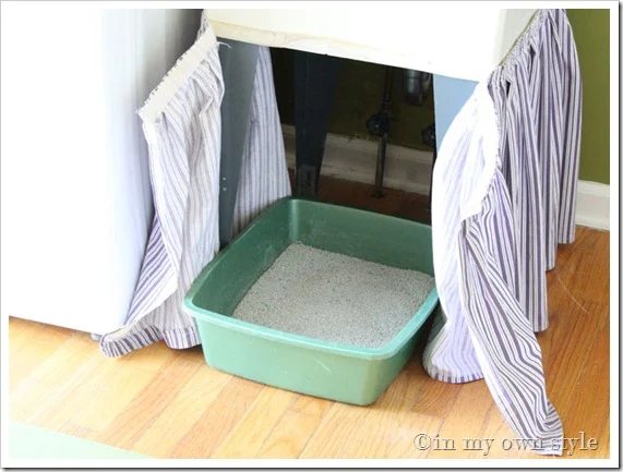 Skirted fabric attached around a laundry room tub sink makes for a good place to hide a litter box that allows the cat to still easily use it.