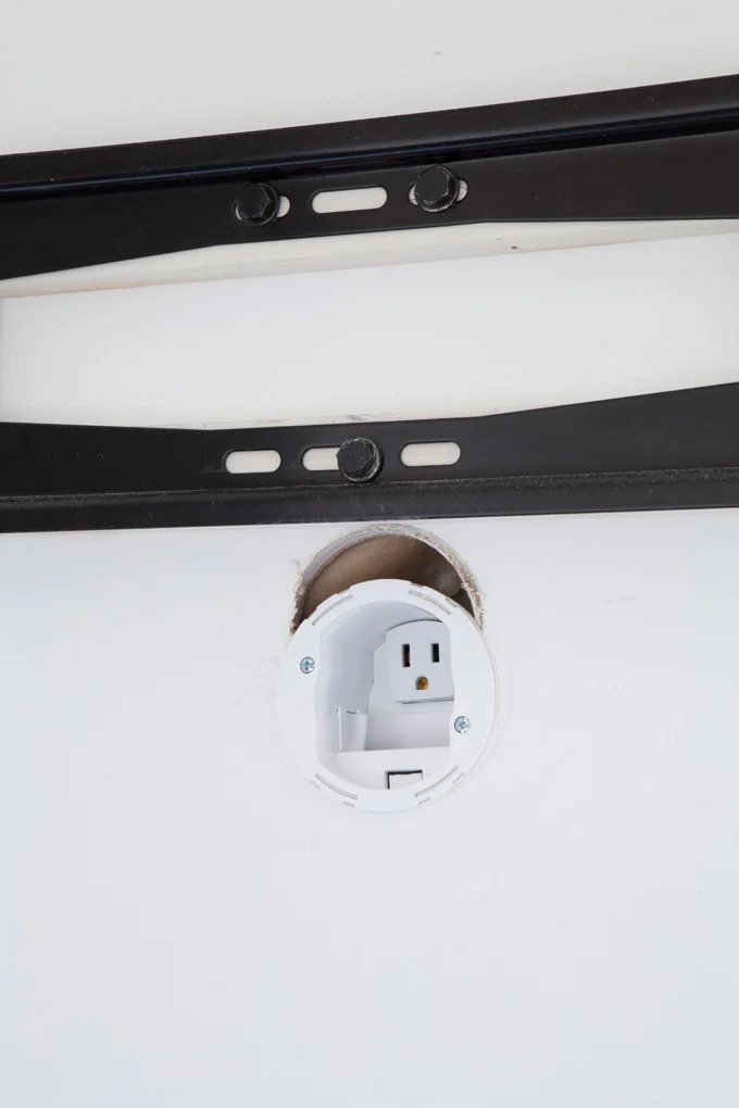 Close up of TV cord hiding kit and outlet on wall.