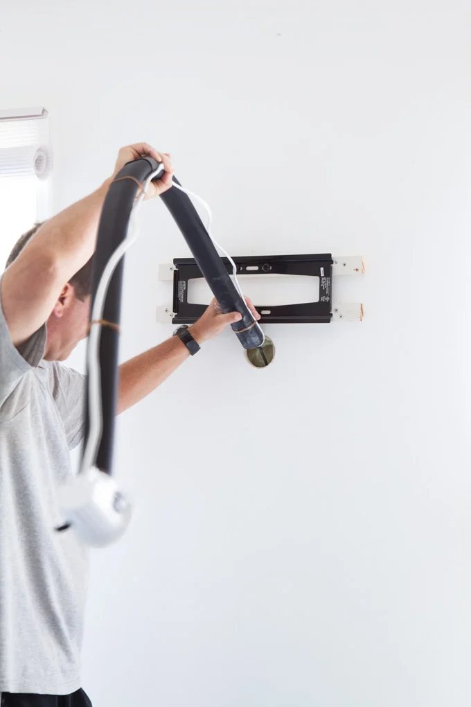 Man placing kit tube through the holes he drilled.