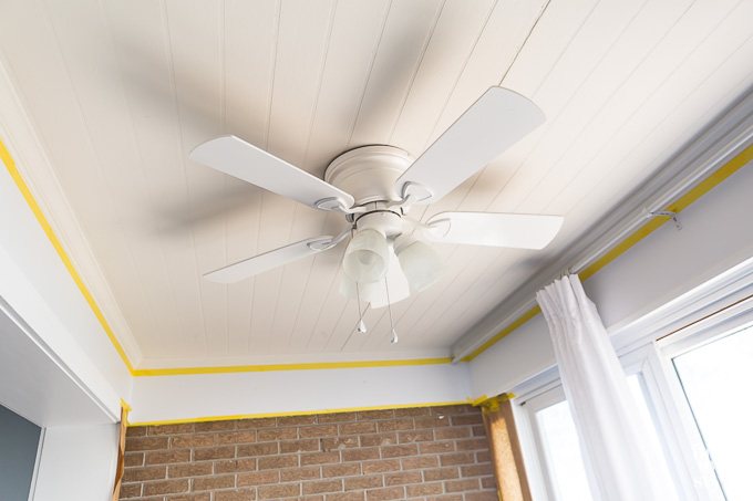 White ceiling fan hanging from white bead board ceiling