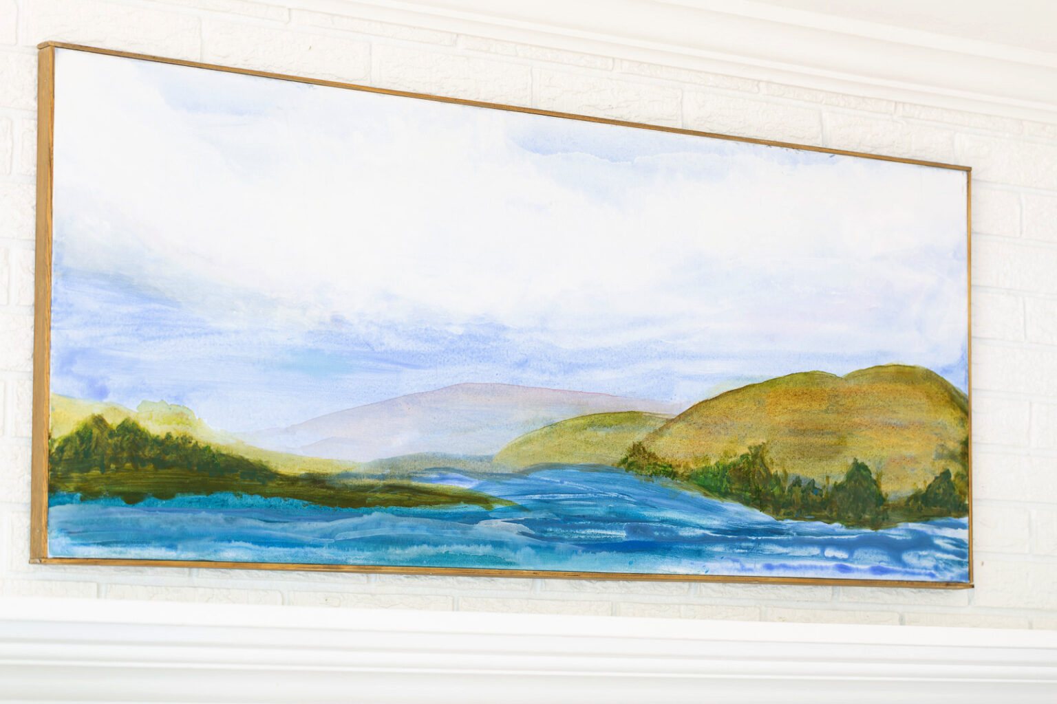 Finished, framed and hung on wall painted art canvas with a water and mountain scene.