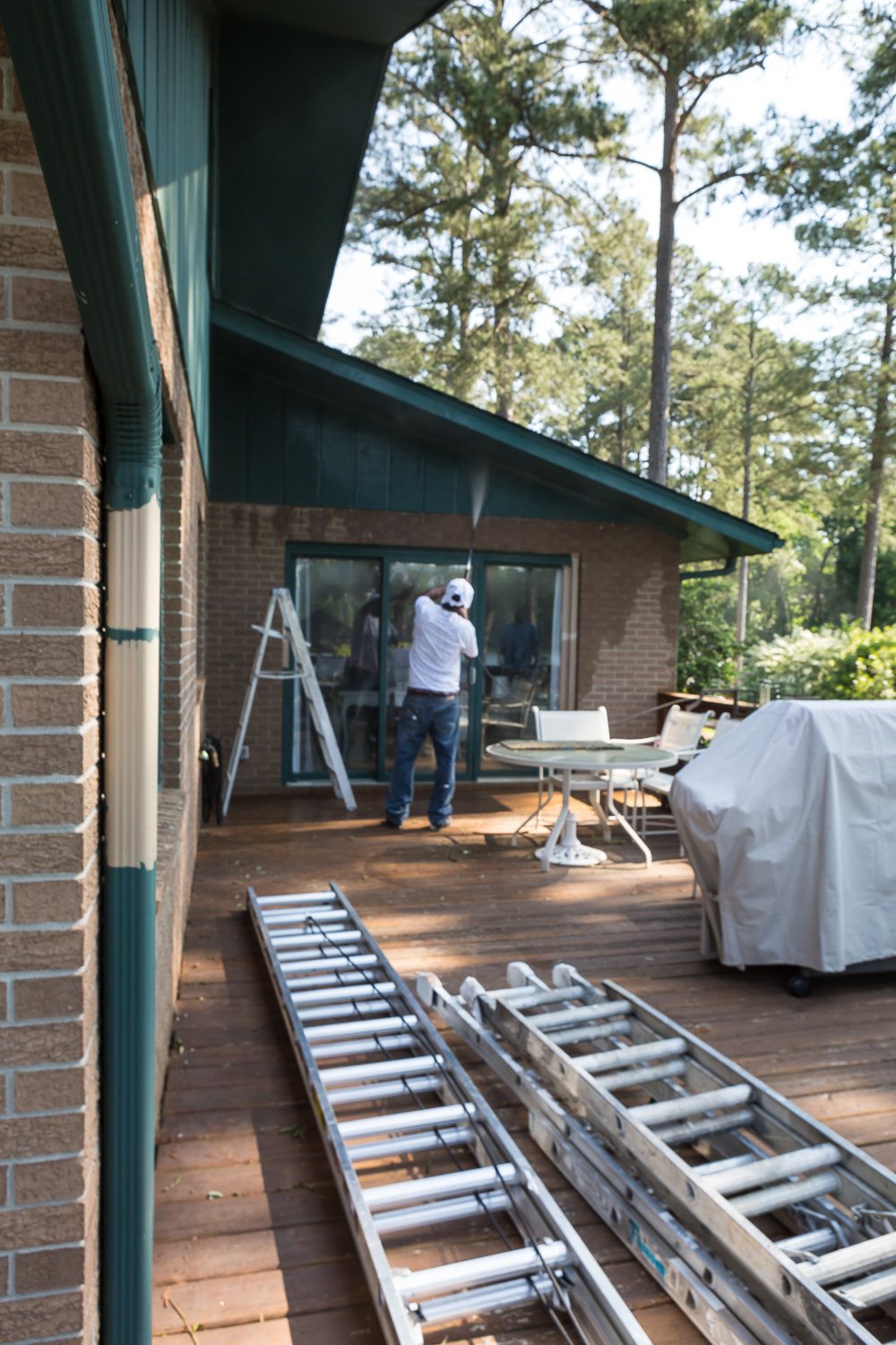 ladders on deck getting ready to paint the exterior of a house