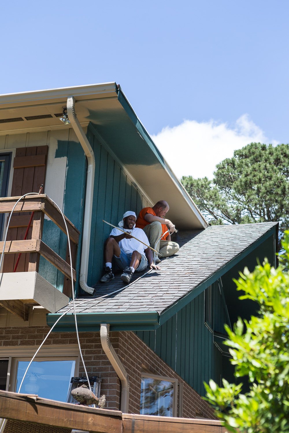 Painters on roof painting house