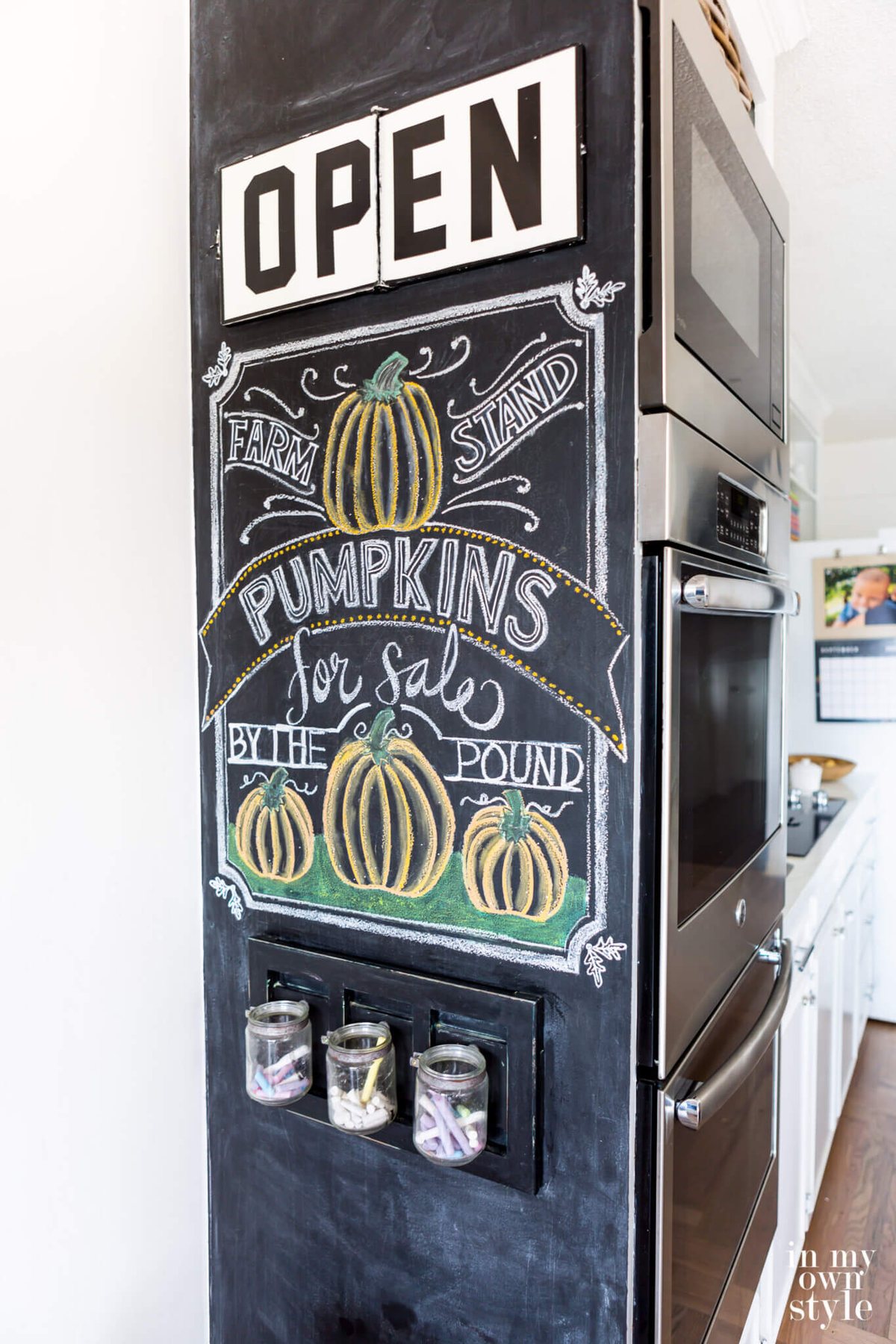 Fall chalkboard art on wall painted with chalkboard paint. Art says Farm Stand Pumpkins for Sale by the pound.