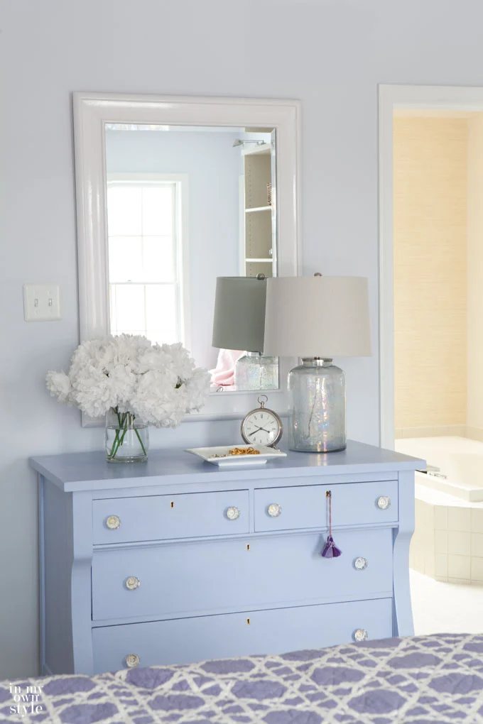 glossy white paint on mirror above blue dresser in bedroom that helps to brighten a dark room