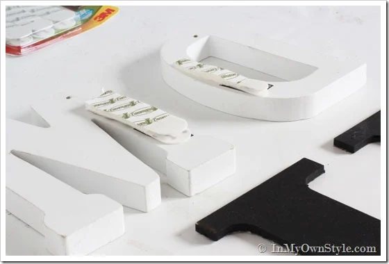How to hang wood initials and layer them inside a gallery wall arrangement.