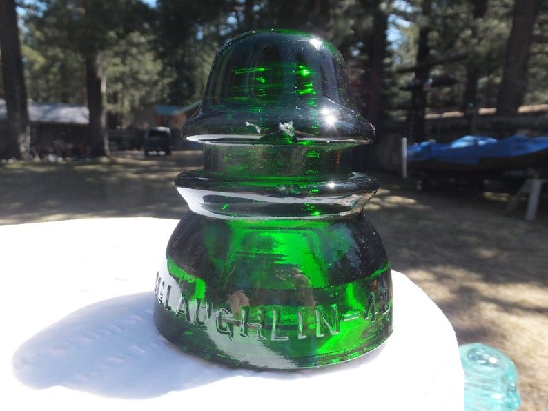 Vintage green glass insulator on table that can be used to decorate a home in a meaningful way.