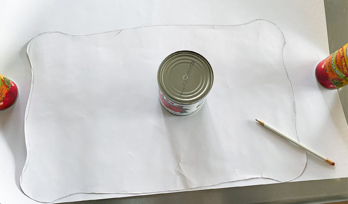 how to cut out paper to decoupage it onto furniture. Use food cans to hold paper down.