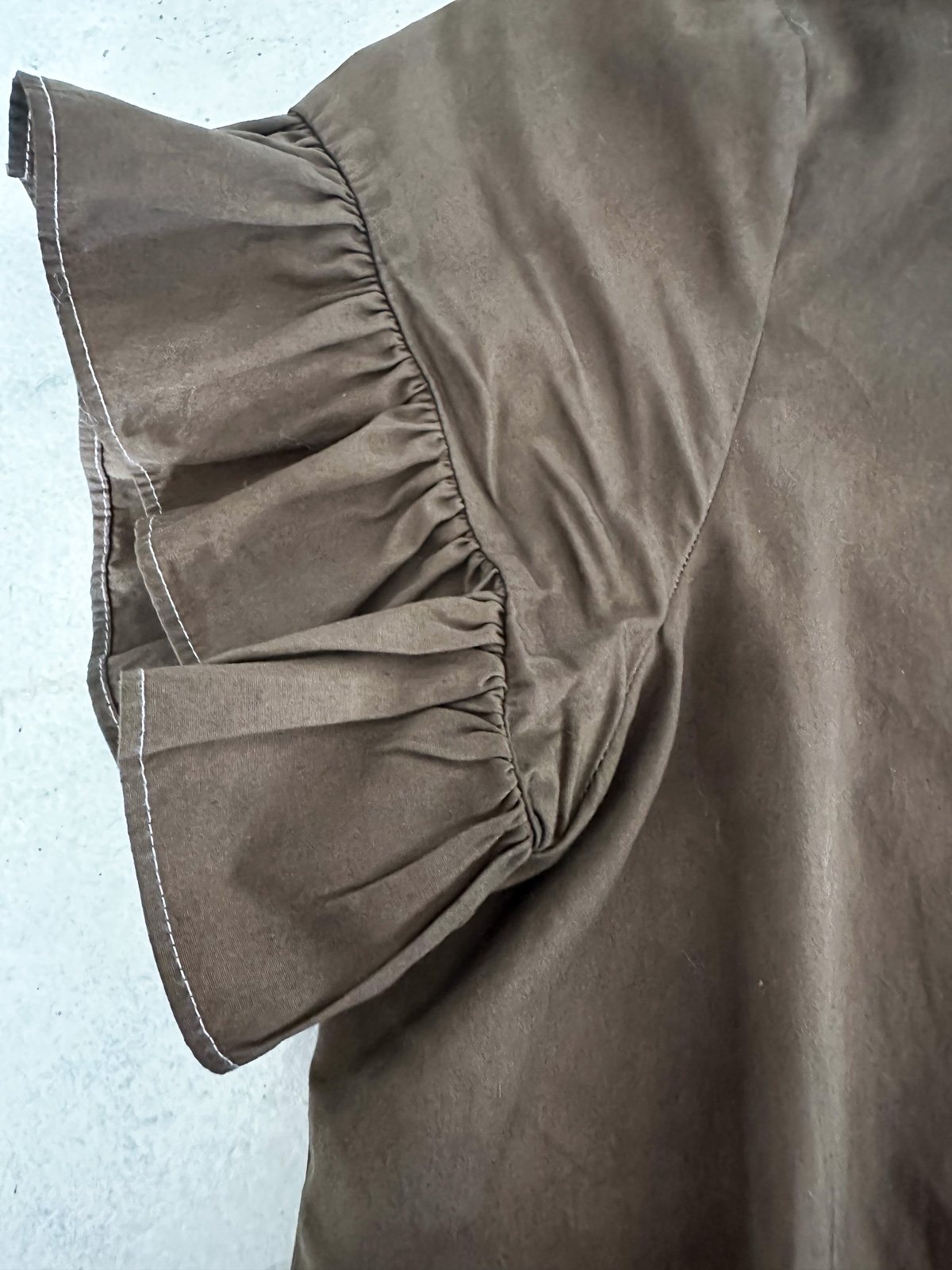 close up of white dress that was dyed brown where white thread didn't dye.