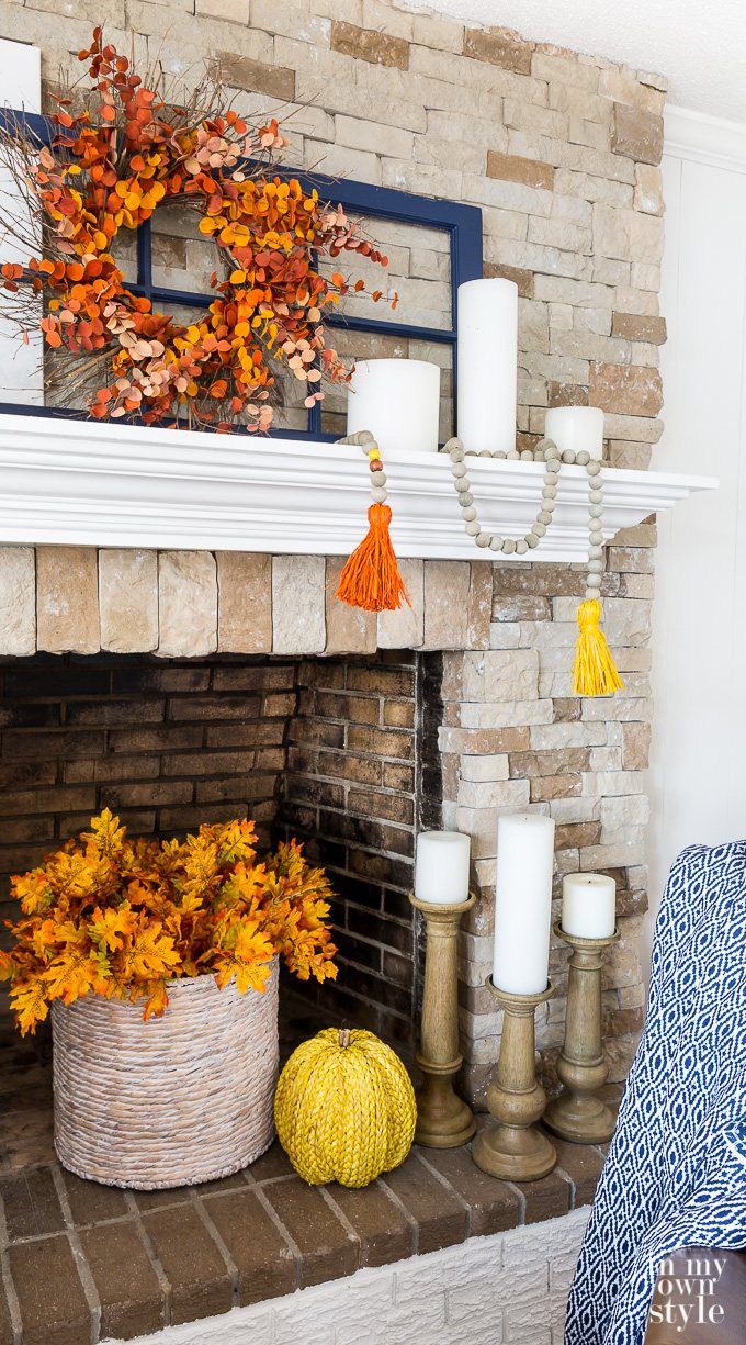 Fall decorations on stone fireplace with white mantel