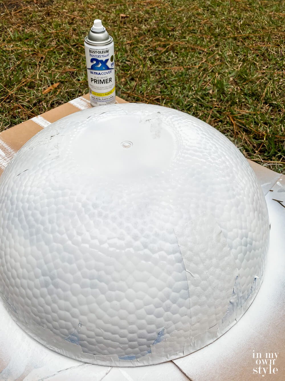 Spray painting primer on large clear plastic bowls.