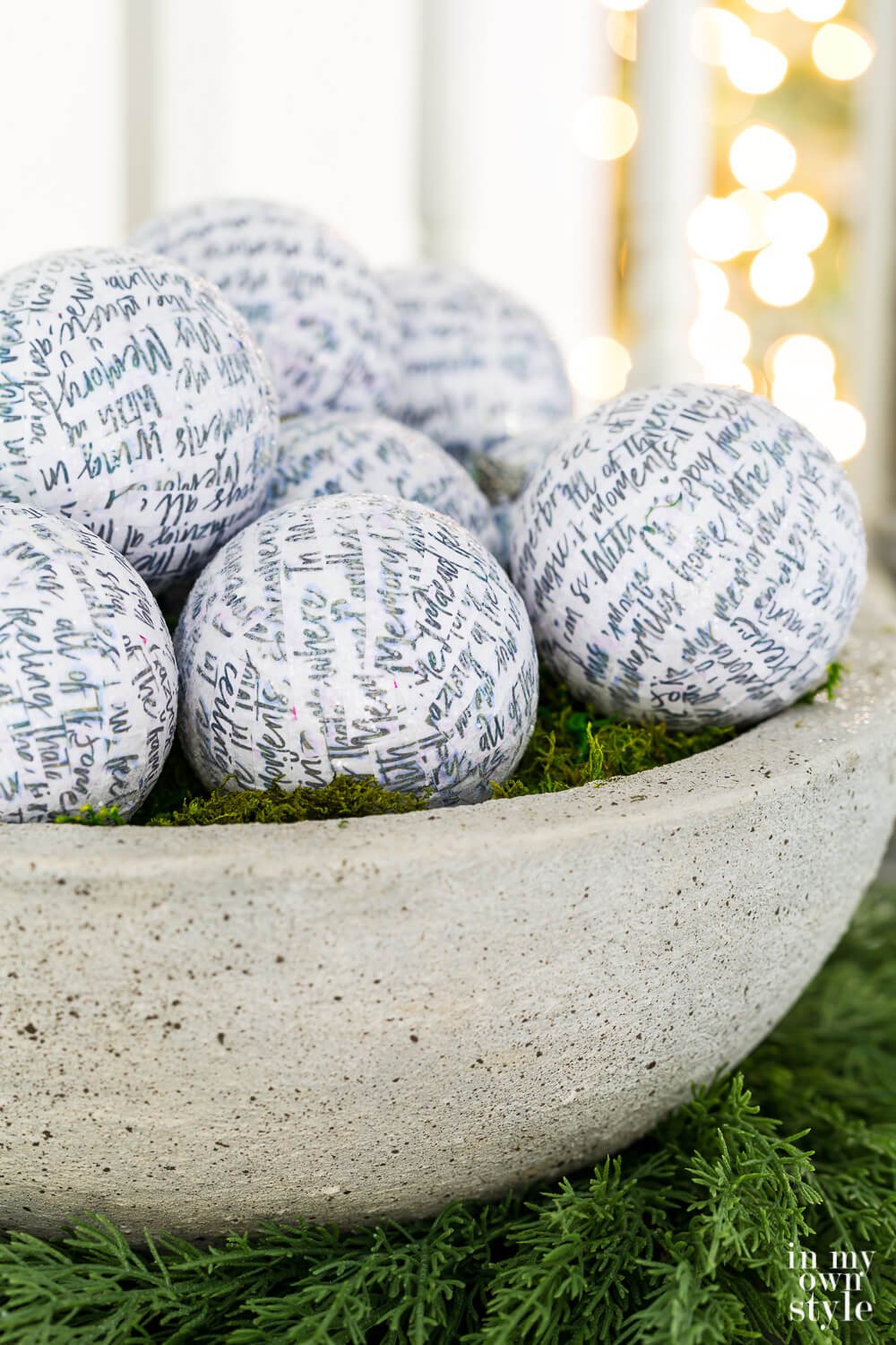 DIY faux large cast stone planter bowl filled with white glittered Christmas ornaments.