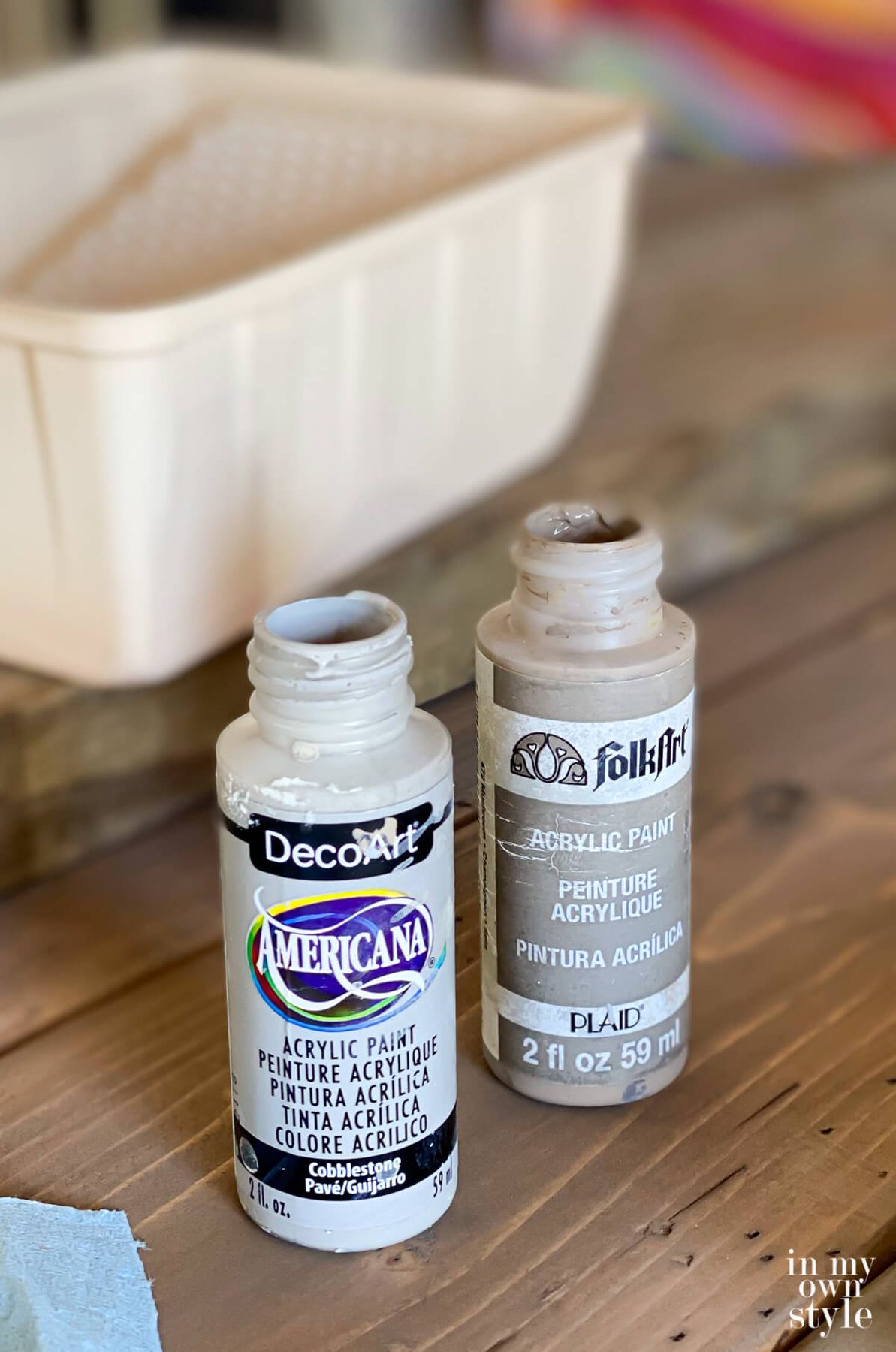 grey craft paints used to add a grey wash over a stained DIY round wood table top.