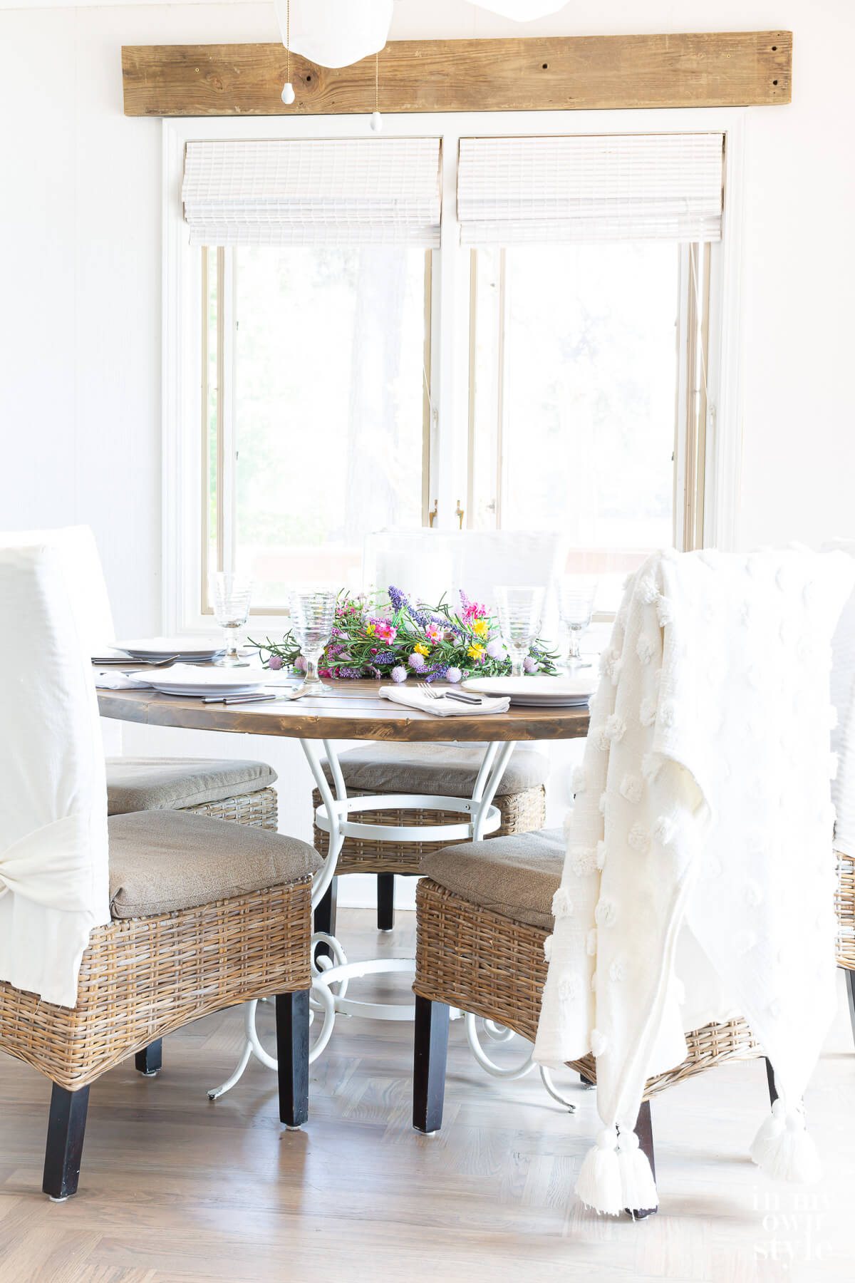 DIY round wood table attached to a white metal base. Chairs around the table.