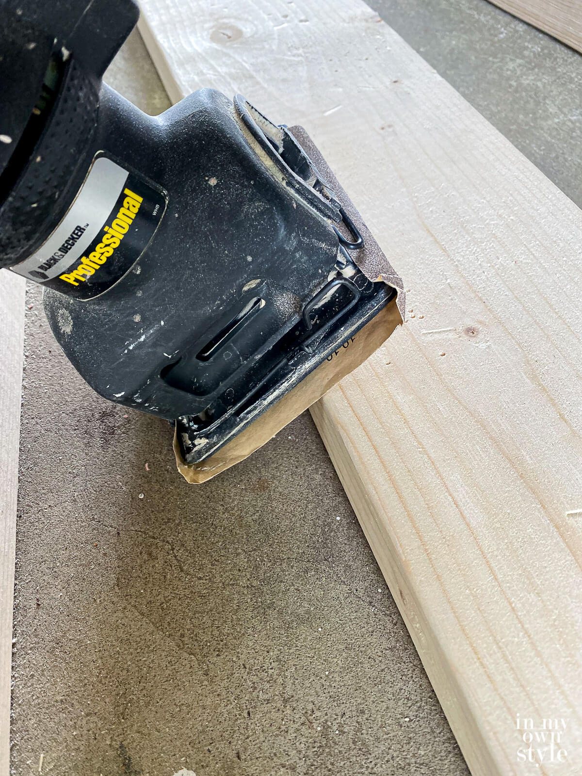 Sanding edge of each pine board before assembling table.