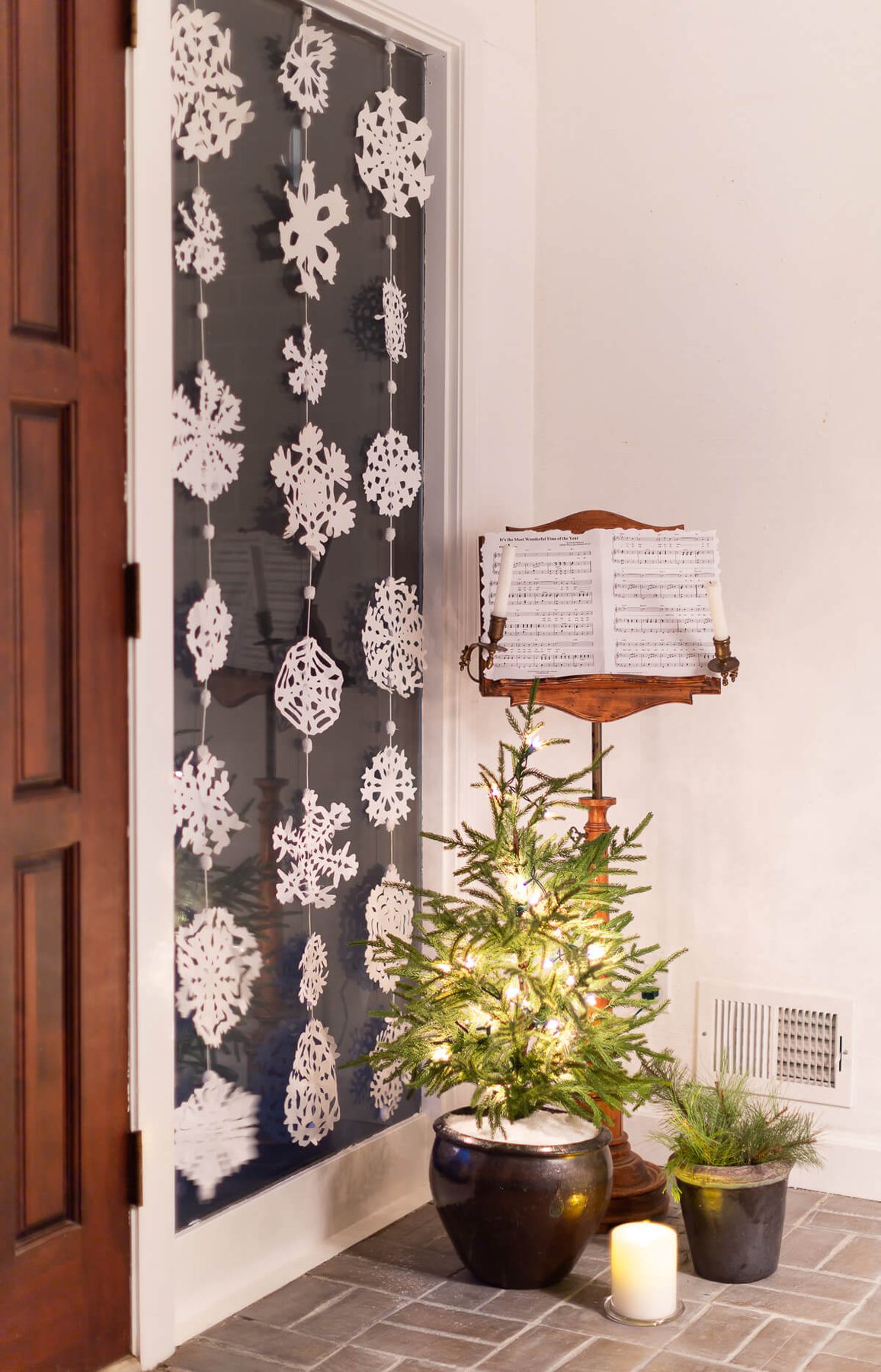 Snowflake window decor. 3 rows of Paper snowflakes hung in a tall window for winter decor.