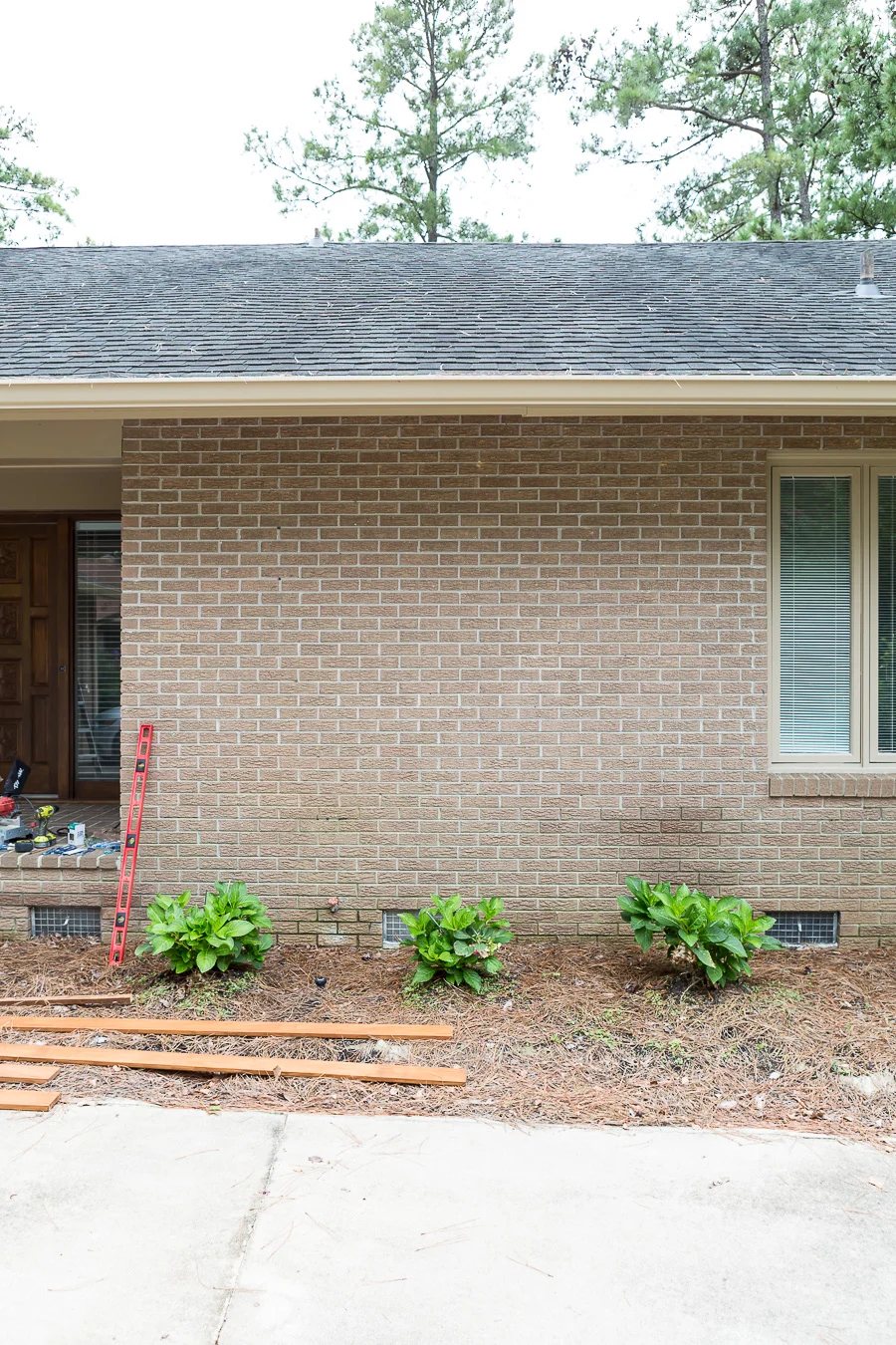 Before photo of plain brick Ranch style home