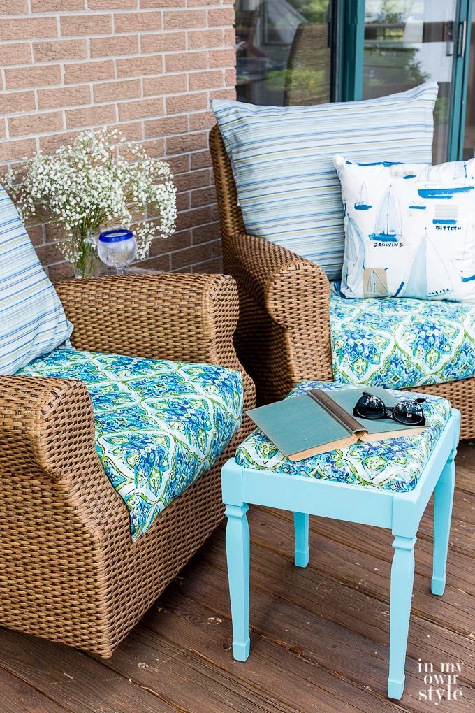 Two rattan rockers with painted stool between them.