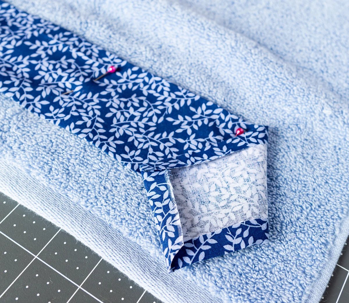 hemmed fabric pinned to a towel before sewing.