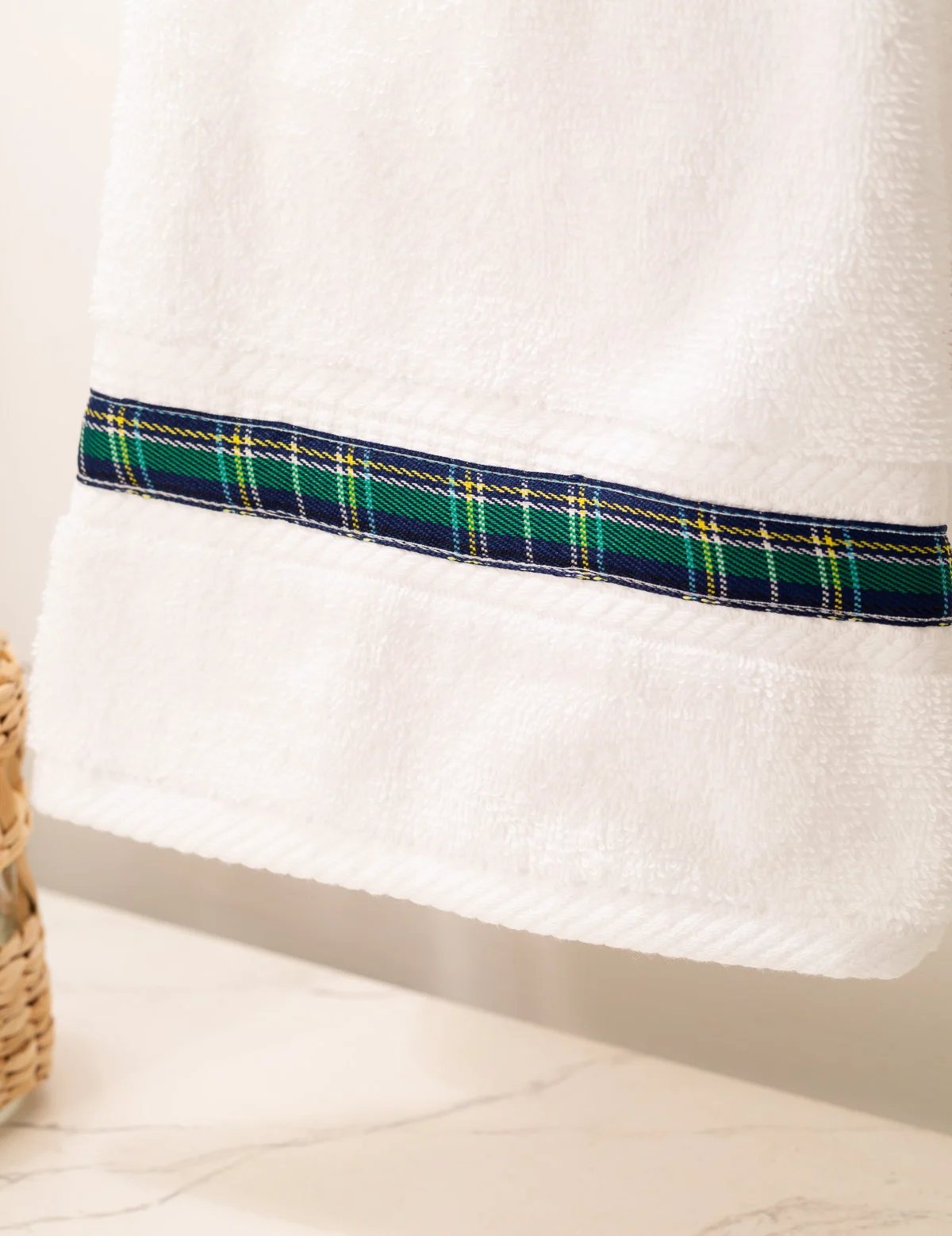 white hand towel with blue plaid ribbon embellishment.