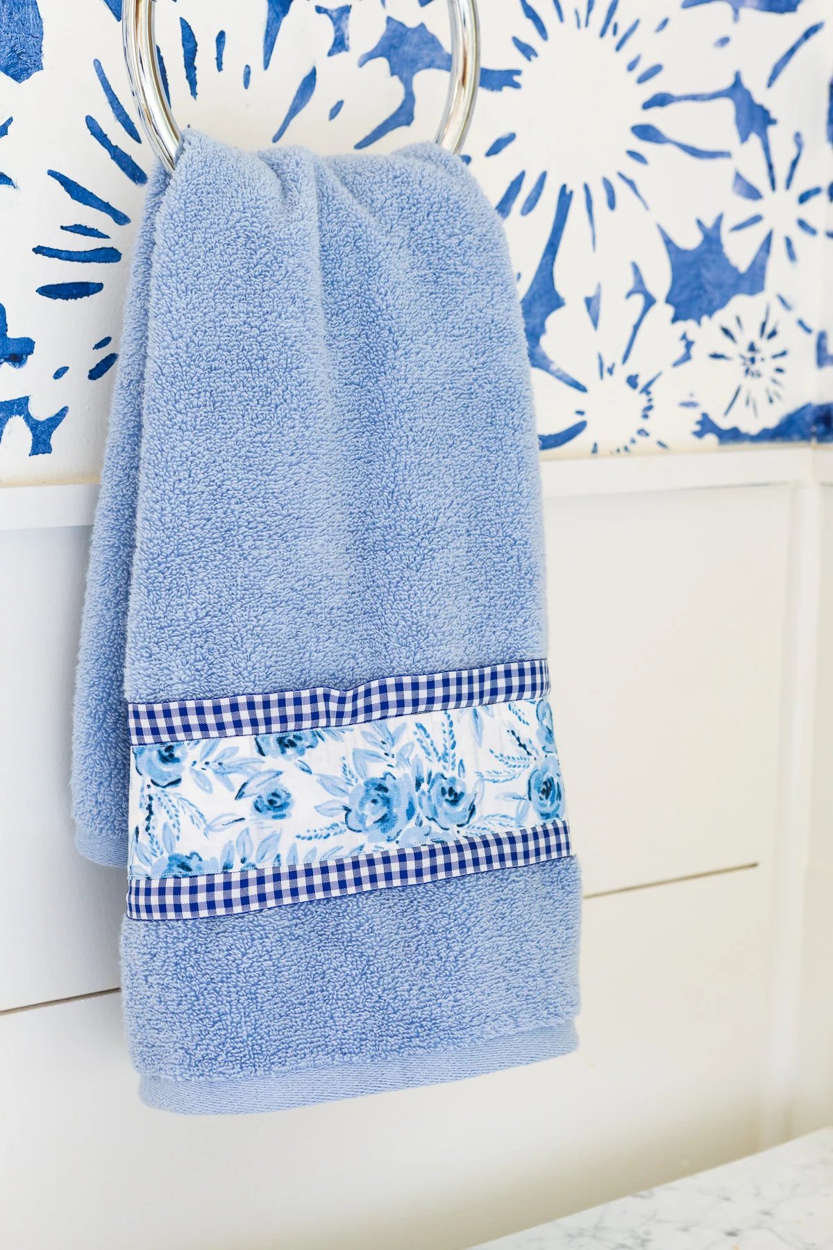 close up of a blue towel with ribbon and fabric added to it to make it more interesting and to coordinate with the decor.