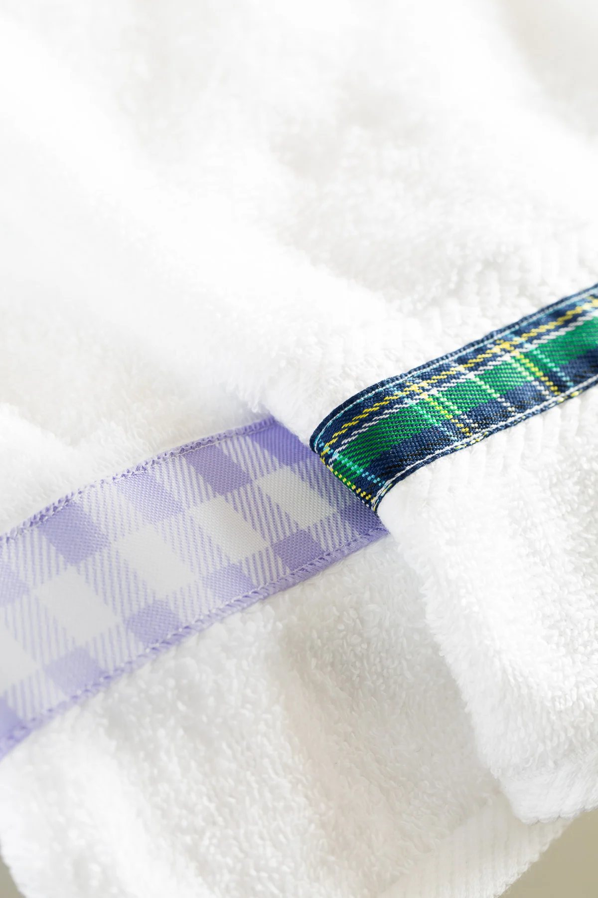 close up ot added ribbon on white bath towels.