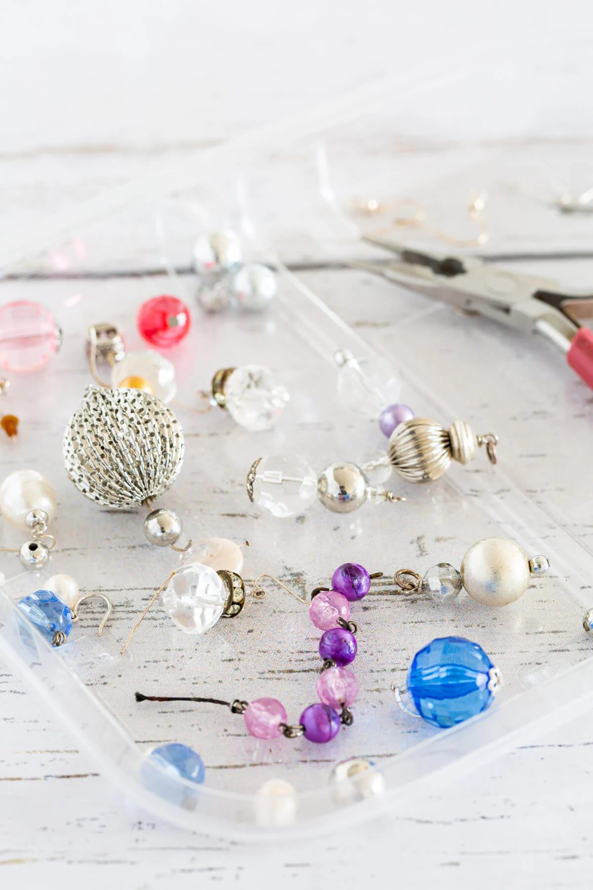 beads to make earrings spread out on a clear tray.