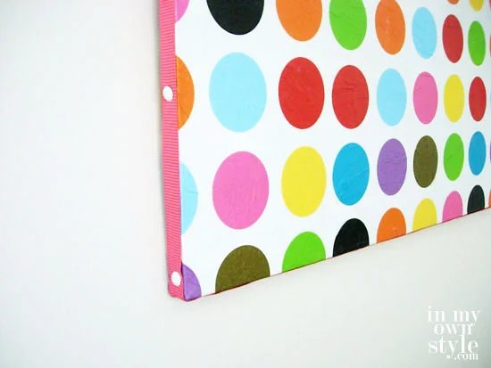 Circle printed tissue paper covered canvas with ribbon trim around the outer edges.